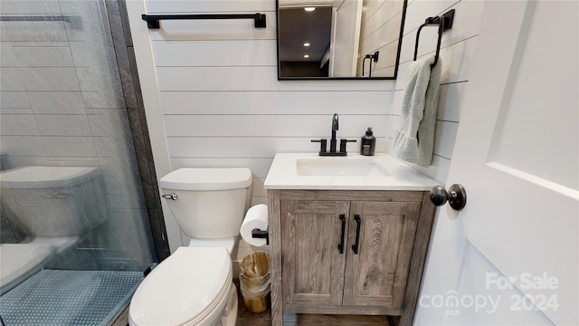 bathroom with a tile shower, vanity, and toilet