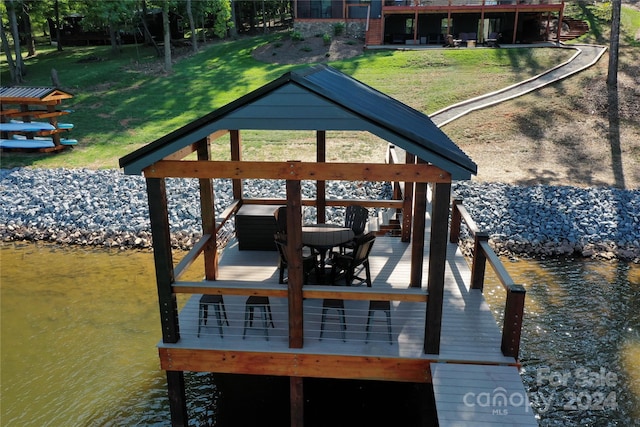 view of dock featuring a lawn and a water view