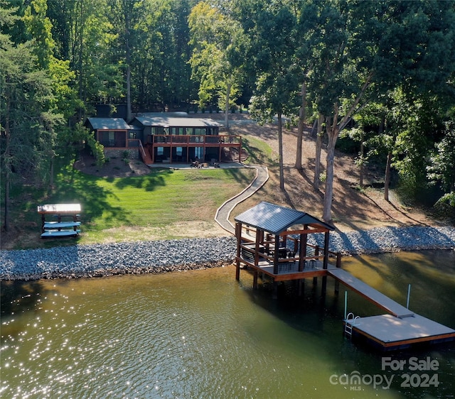 view of dock featuring a deck with water view and a lawn