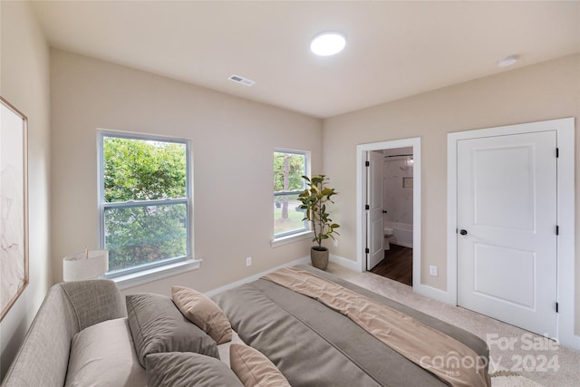 bedroom featuring connected bathroom and carpet floors