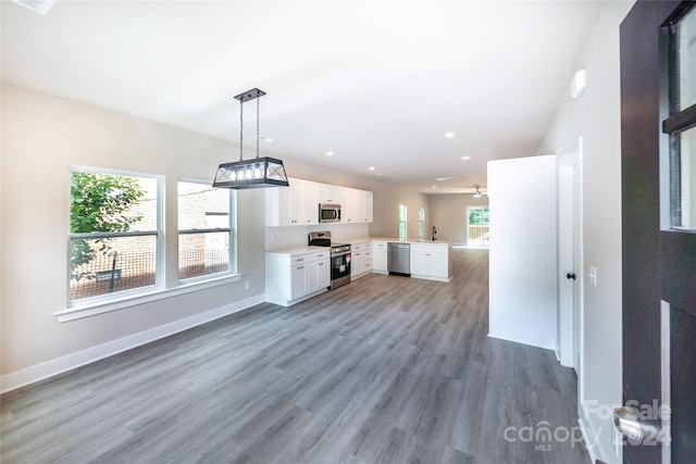 kitchen featuring a wealth of natural light, dark hardwood / wood-style flooring, white cabinets, and stainless steel appliances