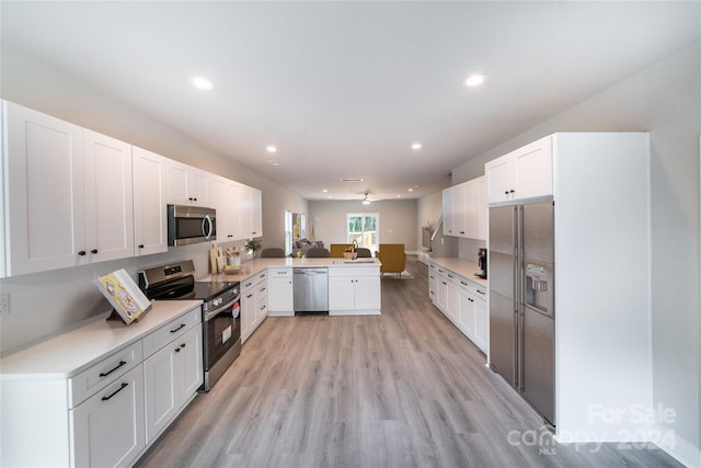 kitchen featuring kitchen peninsula, stainless steel appliances, ceiling fan, light hardwood / wood-style flooring, and white cabinetry