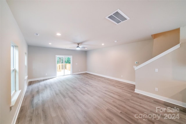 empty room with ceiling fan and light hardwood / wood-style floors