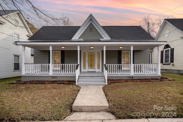 view of front facade with a porch and a yard