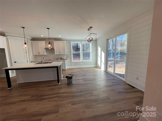 kitchen featuring dark wood-type flooring, light countertops, a healthy amount of sunlight, and white cabinetry