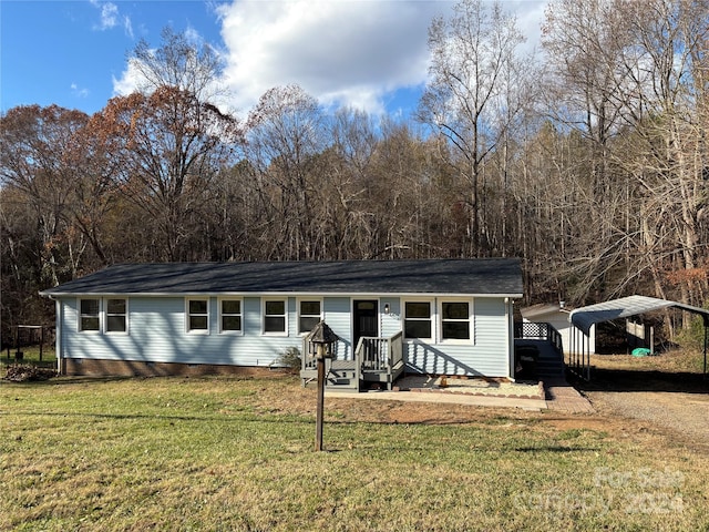 rear view of house featuring a carport and a yard