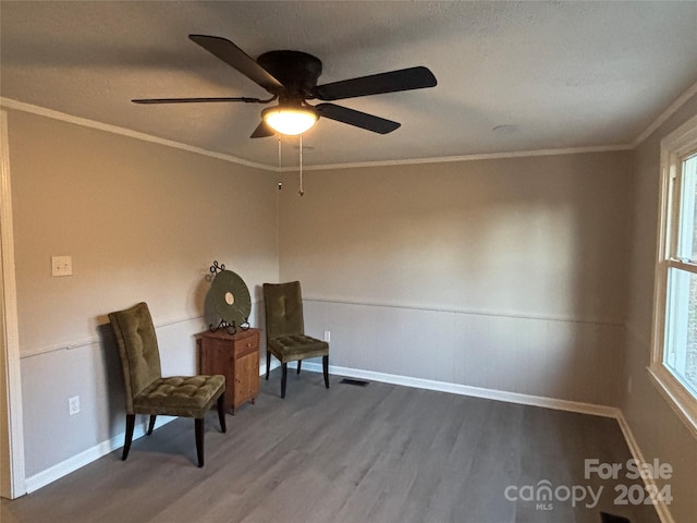 living area with ceiling fan, wood-type flooring, a textured ceiling, and ornamental molding