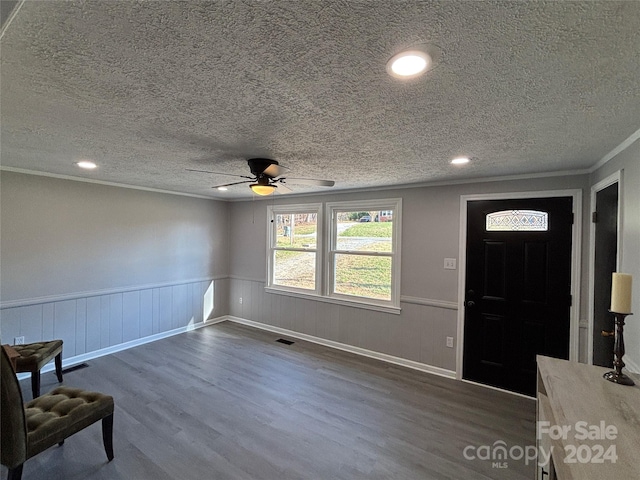 entryway with a textured ceiling, ceiling fan, dark hardwood / wood-style floors, and ornamental molding