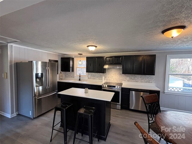 kitchen featuring a center island, a kitchen breakfast bar, sink, light wood-type flooring, and appliances with stainless steel finishes