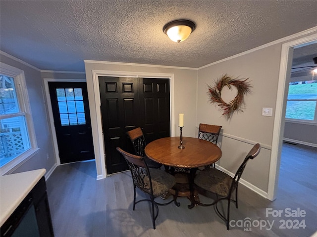 dining room with crown molding, a healthy amount of sunlight, a textured ceiling, and wood-type flooring