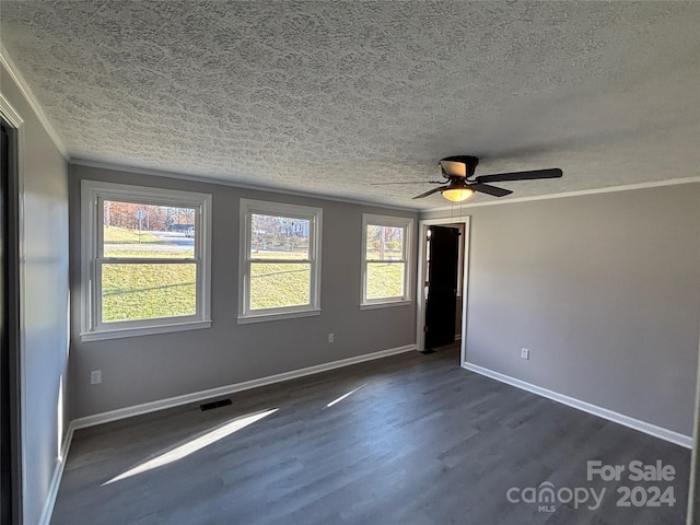 empty room featuring a textured ceiling, dark hardwood / wood-style floors, ceiling fan, and ornamental molding