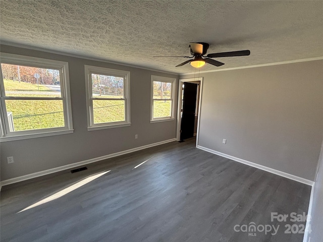 spare room with crown molding, ceiling fan, dark wood-type flooring, and a textured ceiling