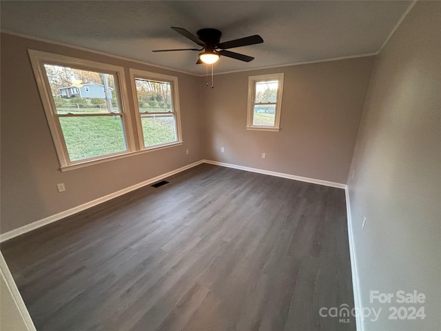 empty room with dark hardwood / wood-style floors, ceiling fan, and ornamental molding