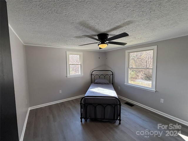 unfurnished bedroom with ceiling fan, dark wood-type flooring, and a textured ceiling