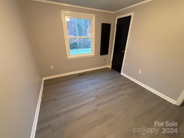 spare room with crown molding and wood-type flooring