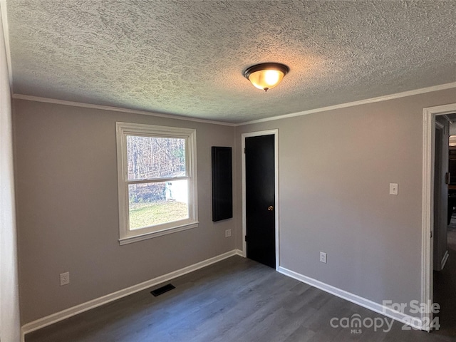 unfurnished room featuring a textured ceiling, crown molding, and dark hardwood / wood-style floors