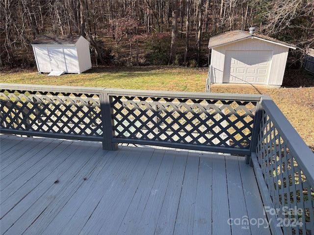 deck featuring a garage, a storage shed, and a yard