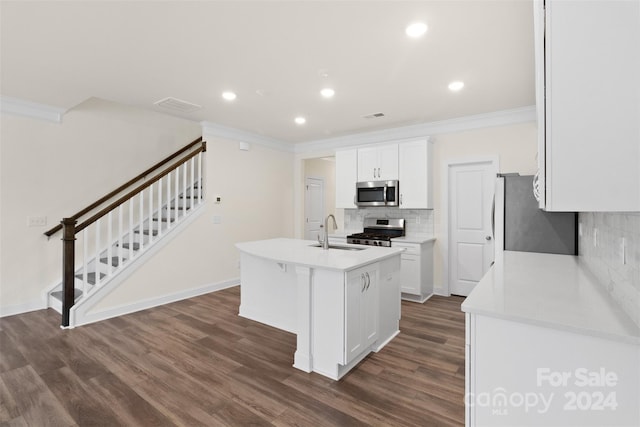 kitchen with a kitchen island with sink, white cabinets, crown molding, dark hardwood / wood-style floors, and stainless steel appliances