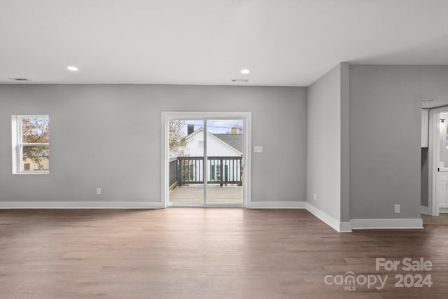 unfurnished living room with hardwood / wood-style flooring and a wealth of natural light