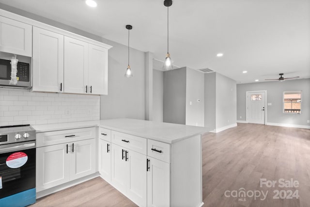 kitchen with white cabinets, hanging light fixtures, light wood-type flooring, kitchen peninsula, and stainless steel appliances