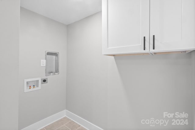 laundry room with cabinets, hookup for a washing machine, light tile patterned floors, and hookup for an electric dryer