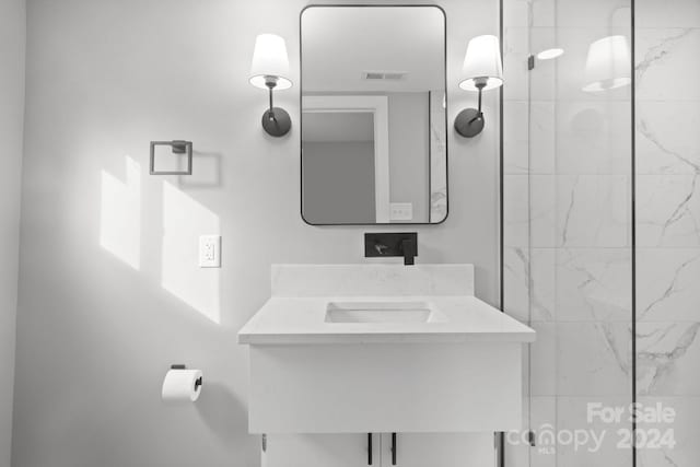 bathroom featuring vanity and tiled shower