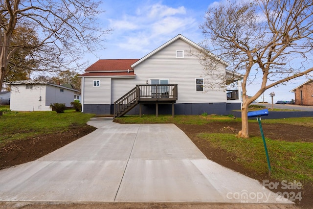 view of front of property featuring a deck and a front yard