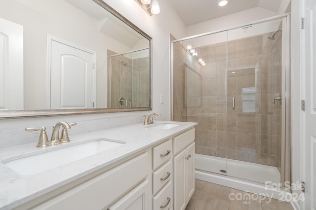 bathroom with tile patterned floors, vanity, and a shower with door