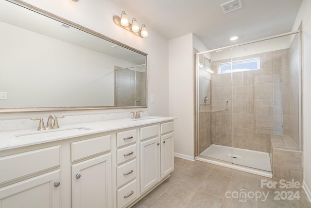 bathroom with tile patterned floors, a shower with door, and vanity