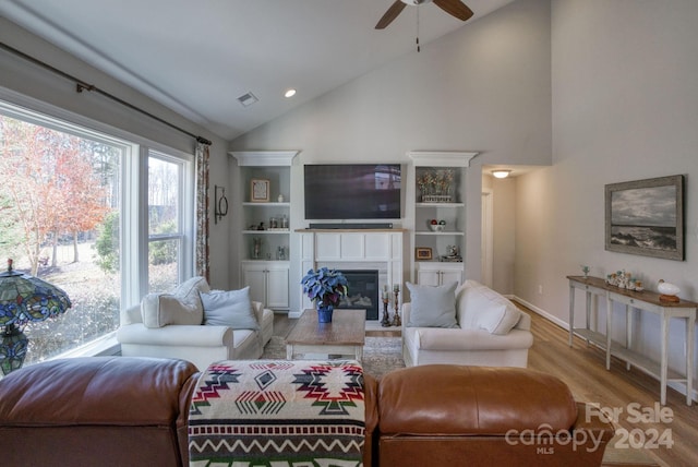 living room featuring high vaulted ceiling, light hardwood / wood-style flooring, and ceiling fan