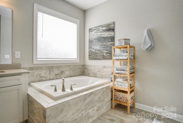 bathroom featuring vanity and tiled bath