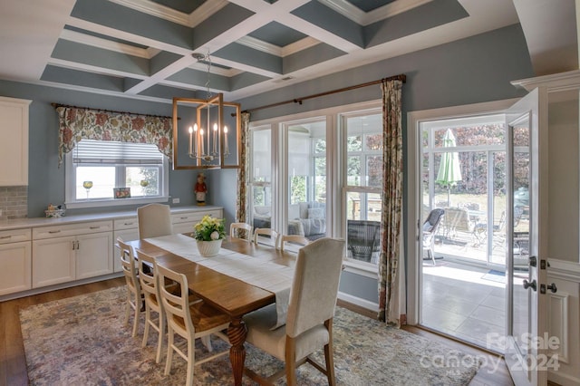 dining area featuring light hardwood / wood-style flooring, plenty of natural light, coffered ceiling, and a notable chandelier