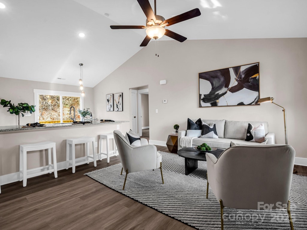 living room with ceiling fan, dark hardwood / wood-style flooring, and vaulted ceiling