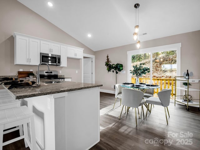 kitchen with stainless steel appliances, decorative light fixtures, white cabinetry, and sink