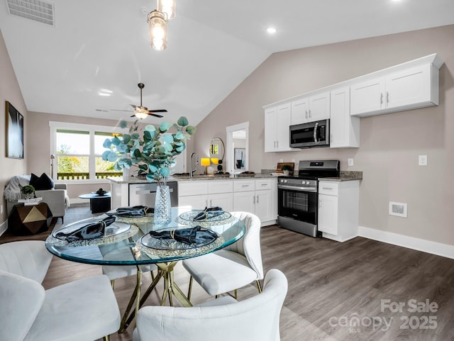 kitchen with sink, stainless steel appliances, dark stone countertops, and white cabinetry