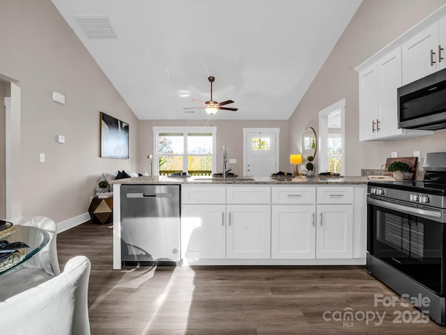 kitchen with stainless steel appliances, white cabinets, sink, and light stone counters