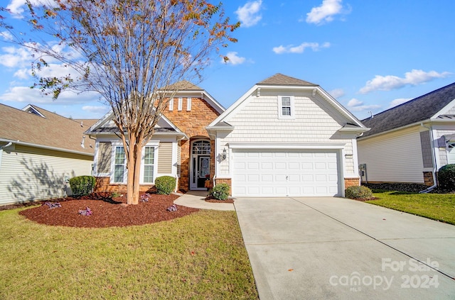 view of property featuring a garage and a front lawn