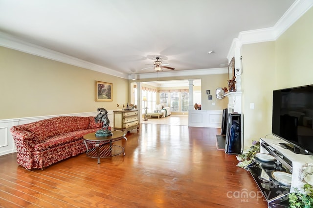 living room with hardwood / wood-style floors, ceiling fan, and crown molding