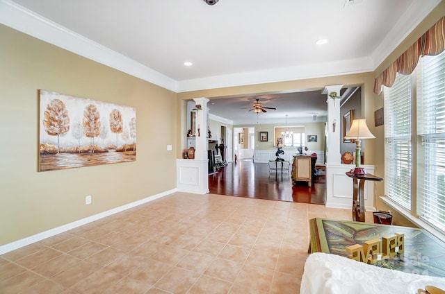 interior space featuring ornate columns, a wealth of natural light, crown molding, and ceiling fan