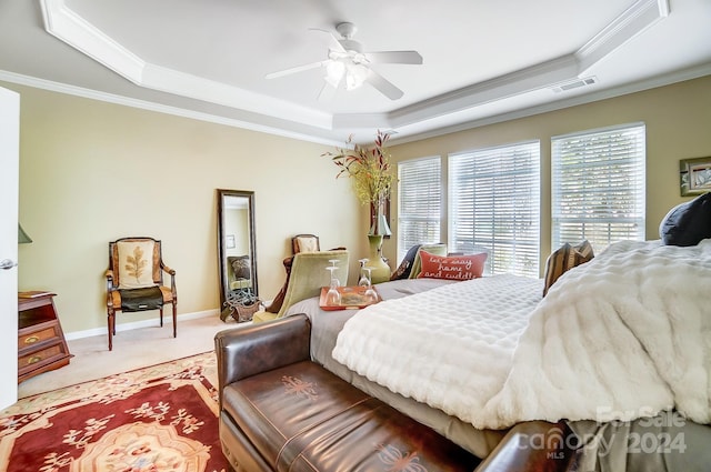 carpeted bedroom with ceiling fan, a raised ceiling, and crown molding