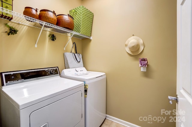 laundry room featuring light tile patterned floors and washing machine and dryer