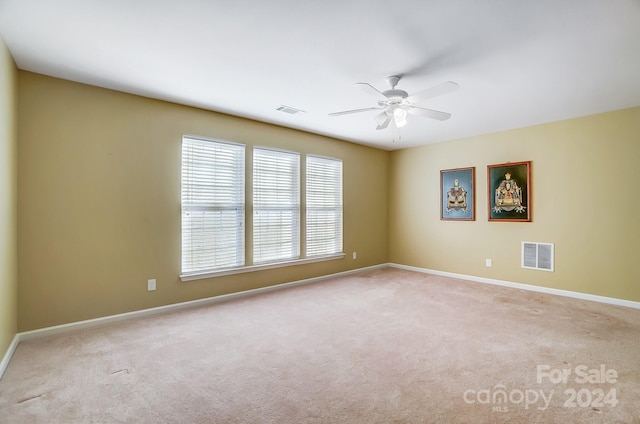 carpeted spare room featuring ceiling fan