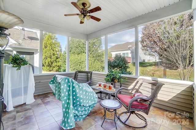 sunroom / solarium featuring ceiling fan and a healthy amount of sunlight