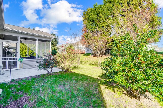 view of yard featuring a sunroom and a patio