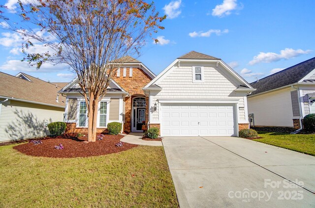 view of front of house featuring a front yard, concrete driveway, and a garage