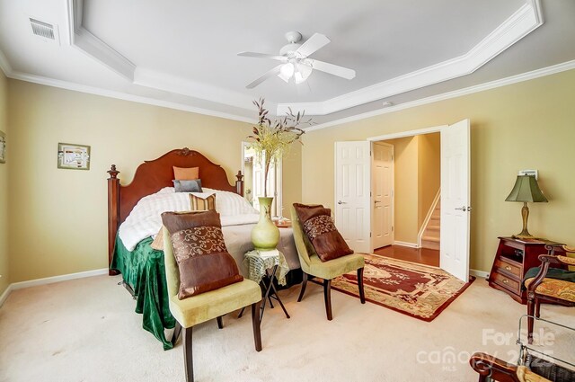 carpeted bedroom with baseboards, a raised ceiling, and ornamental molding