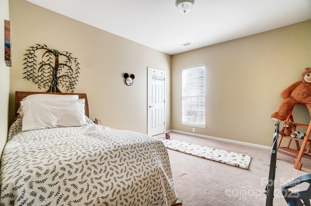 carpeted bedroom featuring visible vents and baseboards