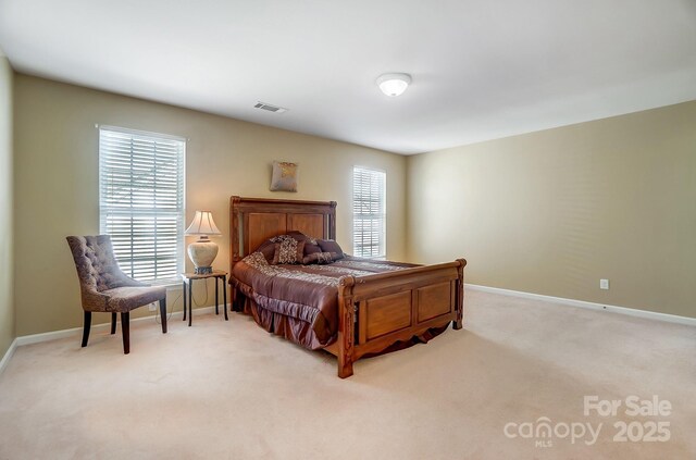 carpeted bedroom with visible vents and baseboards