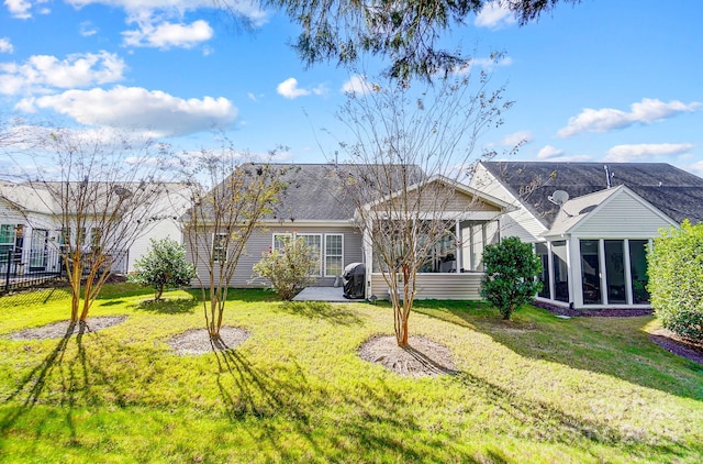 back of house featuring a patio area, a lawn, and a sunroom