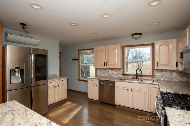 kitchen with decorative backsplash, appliances with stainless steel finishes, a wall mounted AC, dark wood-type flooring, and sink